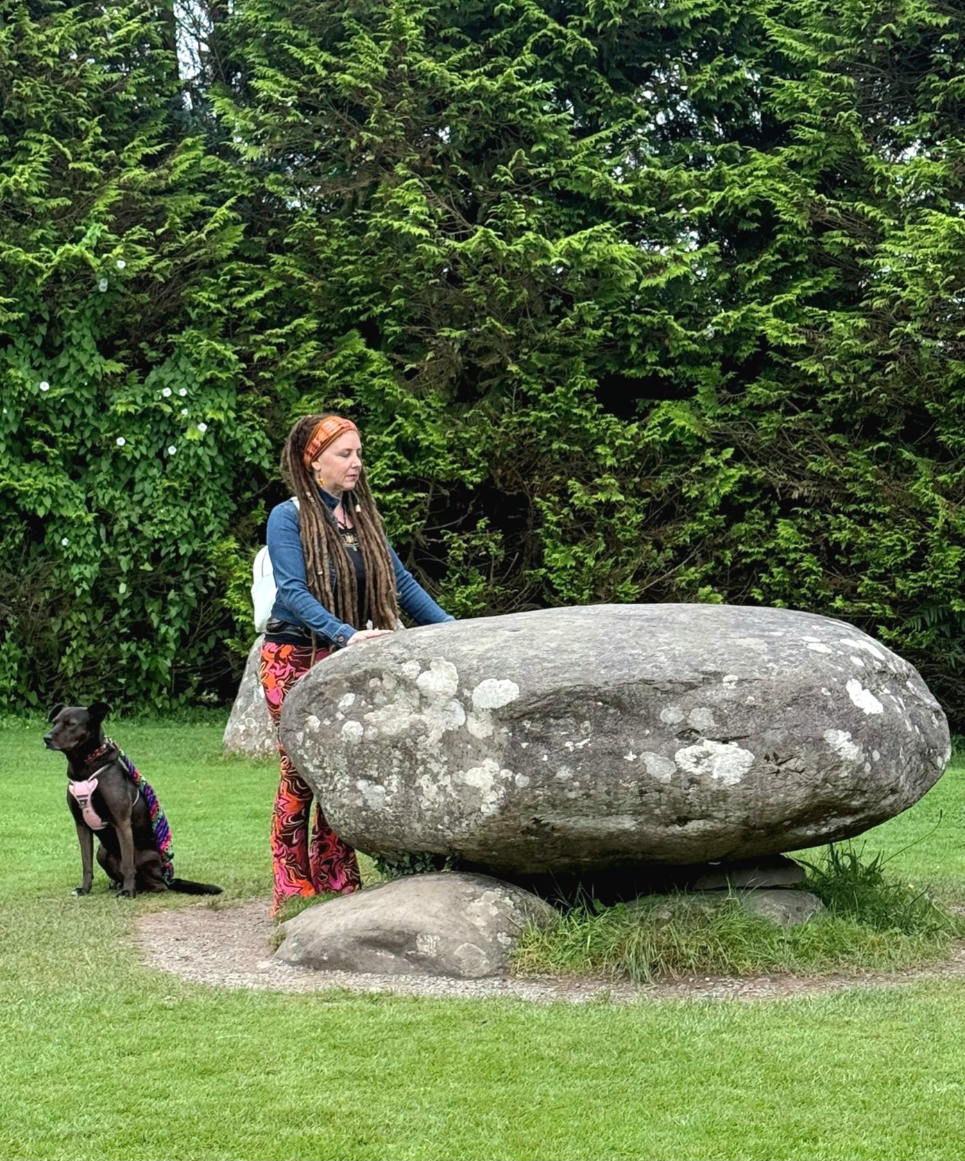Tina-Nomad with her hands on a standing stone